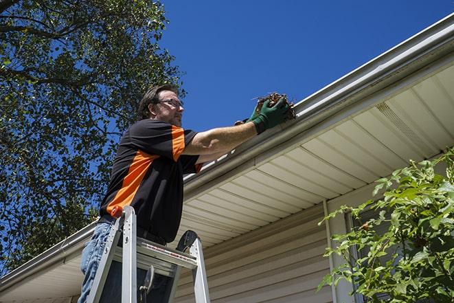 a person replacing a worn-out gutter on a building in Adamstown